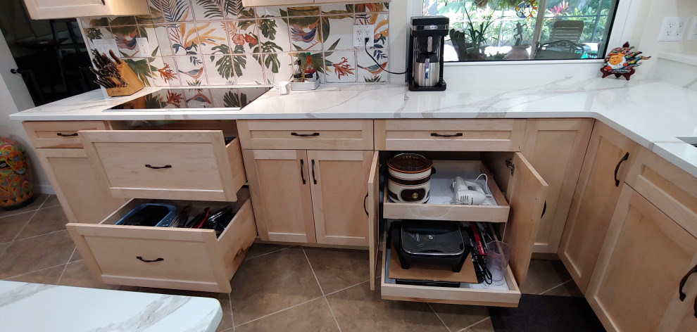 Photo of a large tropical u-shaped open plan kitchen in Tampa with an undermount sink, shaker cabinets, light wood cabinets, quartz benchtops, multi-coloured splashback, cement tile splashback, stainless steel appliances, ceramic floors, with island, beige floor and white benchtop.