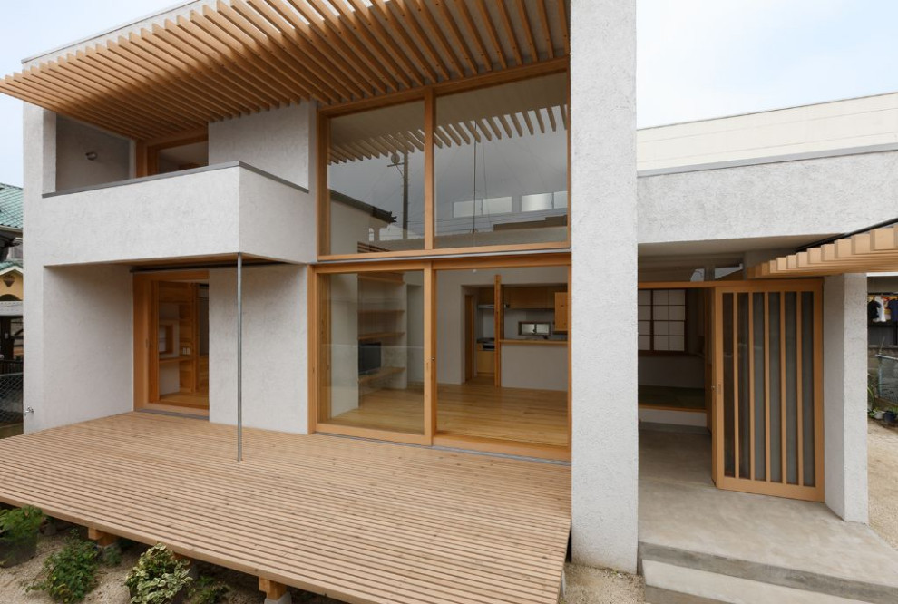 他の地域にある小さなモダンスタイルのおしゃれな二階建ての家 (漆喰サイディング) の写真
