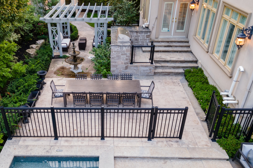 Inspiration for a mid-sized transitional backyard stamped concrete and rectangular pool landscaping remodel in Toronto