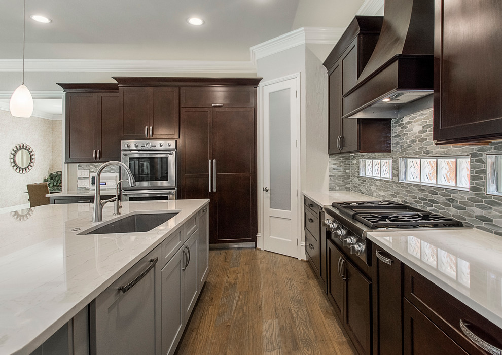 Inspiration for a large transitional l-shaped light wood floor open concept kitchen remodel in Dallas with an undermount sink, shaker cabinets, dark wood cabinets, quartz countertops, metallic backsplash, mosaic tile backsplash, stainless steel appliances and an island