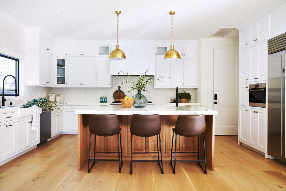 Idéer för ett klassiskt kök och matrum, med rostfria vitvaror, mellanmörkt trägolv, en köksö och brunt golv