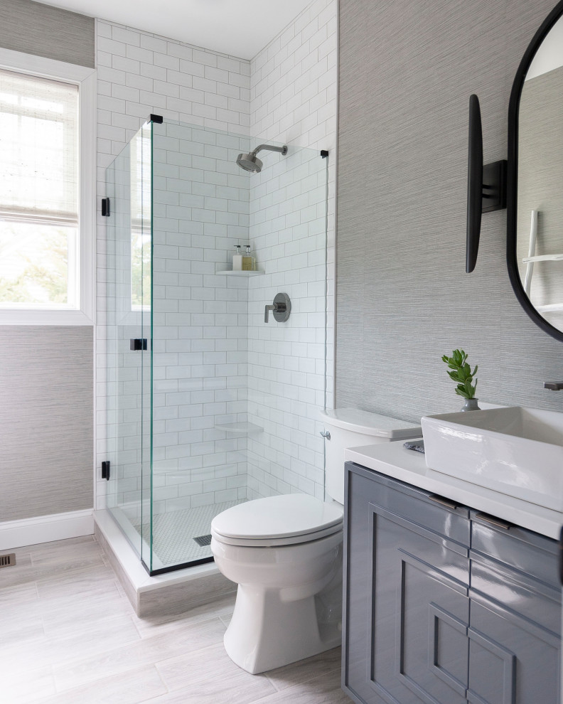 Design ideas for a transitional 3/4 bathroom in Philadelphia with recessed-panel cabinets, grey cabinets, an alcove shower, white tile, subway tile, grey walls, wood-look tile, a vessel sink, beige floor, a hinged shower door, white benchtops, a single vanity, a built-in vanity and wallpaper.