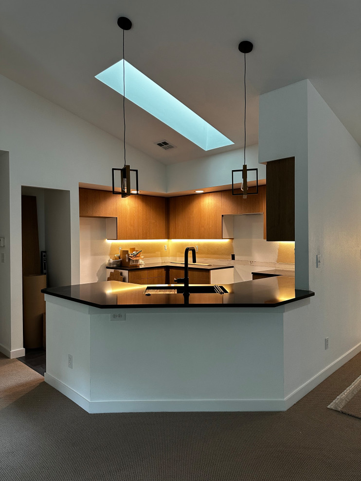Small eclectic u-shaped vinyl floor, gray floor and vaulted ceiling kitchen pantry photo in Seattle with a double-bowl sink, flat-panel cabinets, brown cabinets, quartz countertops, brown backsplash, porcelain backsplash, stainless steel appliances, a peninsula and black countertops