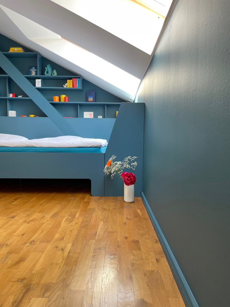 Diseño de dormitorio principal actual de tamaño medio con paredes azules, suelo de madera clara, suelo marrón y vigas vistas