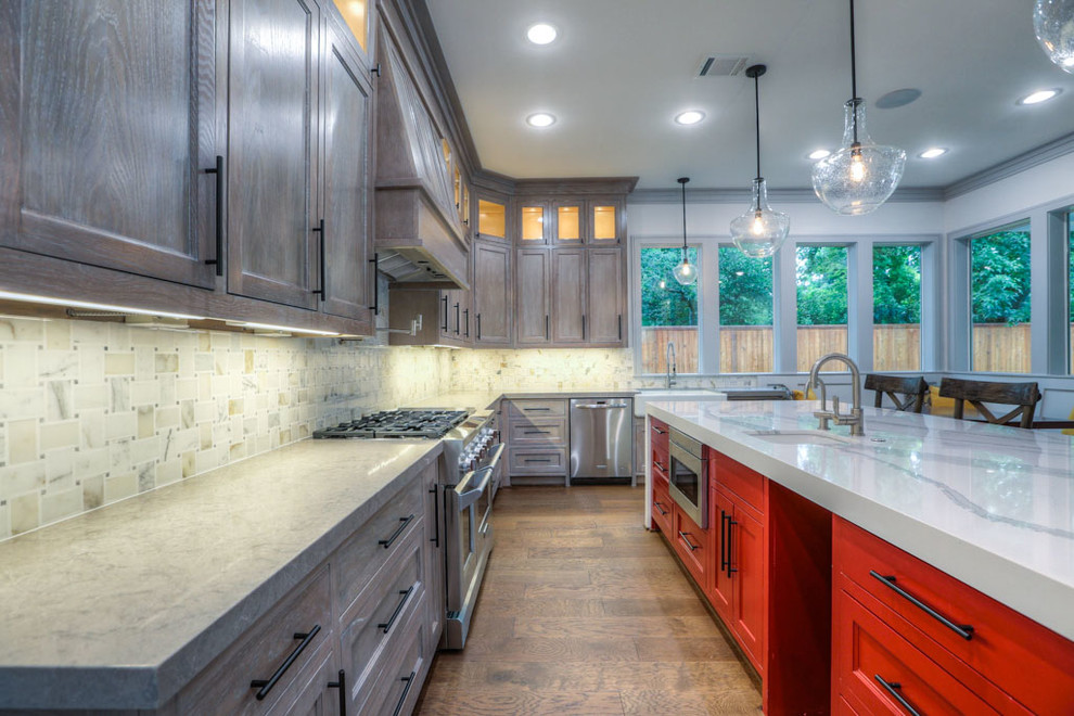 Inspiration for a large arts and crafts u-shaped open plan kitchen in Houston with a farmhouse sink, recessed-panel cabinets, light wood cabinets, quartz benchtops, beige splashback, ceramic splashback, stainless steel appliances, medium hardwood floors, with island and brown floor.