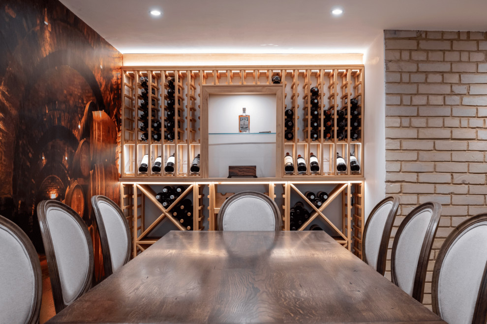 Mid-sized traditional wine cellar in London with display racks.