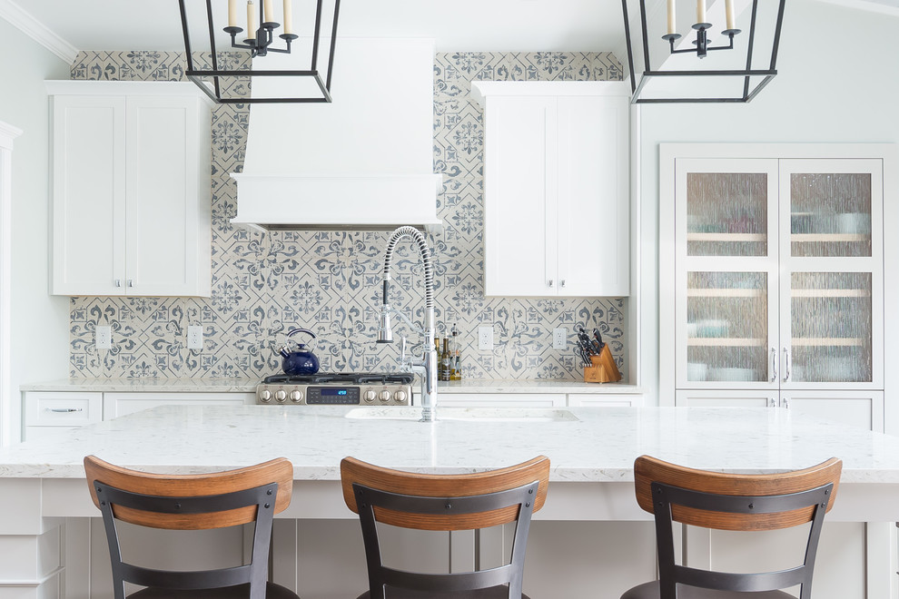 Example of a mid-sized transitional l-shaped porcelain tile and white floor eat-in kitchen design in Raleigh with an undermount sink, shaker cabinets, white cabinets, multicolored backsplash, porcelain backsplash, stainless steel appliances, an island, wood countertops and white countertops