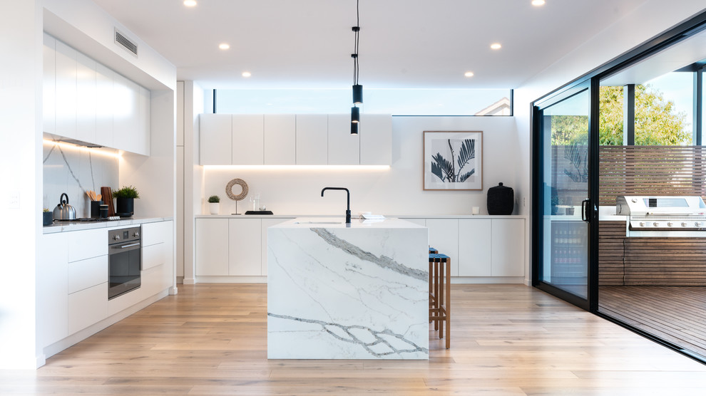 Inspiration for a modern kitchen in Other with a double-bowl sink, white cabinets, marble benchtops, multi-coloured splashback, marble splashback, stainless steel appliances, laminate floors, with island and multi-coloured benchtop.