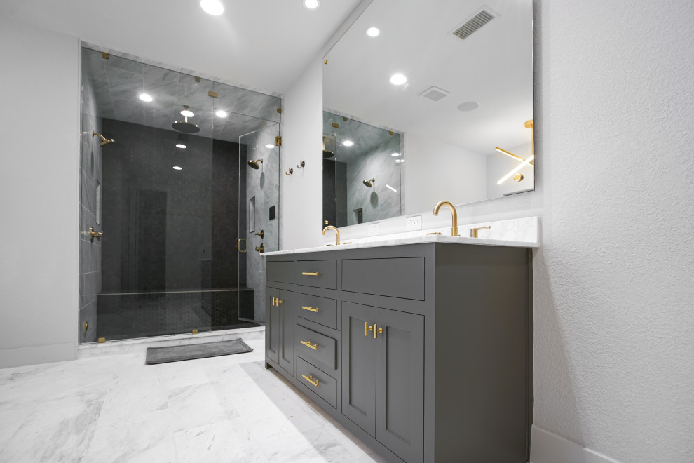 This is an example of a mid-sized midcentury master bathroom in Dallas with recessed-panel cabinets, grey cabinets, a freestanding tub, a double shower, black tile, ceramic tile, grey walls, ceramic floors, a drop-in sink, granite benchtops, grey floor, a hinged shower door, grey benchtops, a shower seat, a double vanity and a built-in vanity.