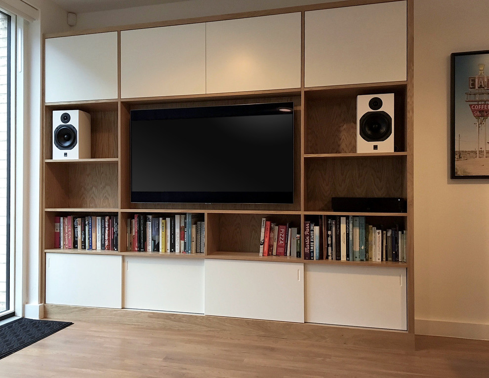 Photo of a large contemporary living room in London with light hardwood floors, a built-in media wall and white walls.