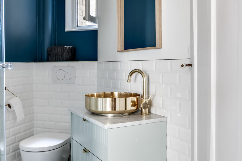 This is an example of a small midcentury bathroom in Paris with green cabinets, a corner shower, a wall-mount toilet, blue tile, ceramic tile, blue walls, cement tiles, a vessel sink, marble benchtops, grey floor, white benchtops, an enclosed toilet, a single vanity and a floating vanity.