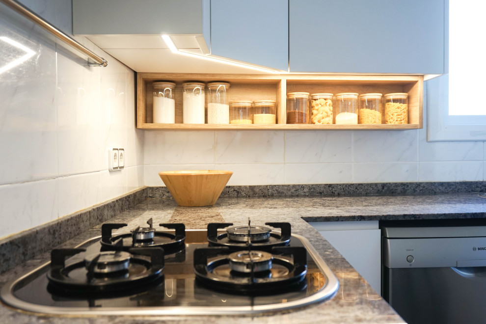 Mid-sized contemporary l-shaped separate kitchen in Barcelona with a double-bowl sink, flat-panel cabinets, white cabinets, marble benchtops, white splashback, ceramic splashback, stainless steel appliances, porcelain floors, a peninsula, black floor and black benchtop.