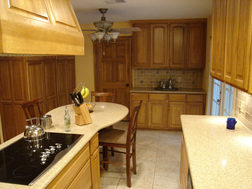Eat-in kitchen - mid-sized transitional l-shaped ceramic tile eat-in kitchen idea in Houston with a double-bowl sink, raised-panel cabinets, light wood cabinets, solid surface countertops, multicolored backsplash, subway tile backsplash, stainless steel appliances and an island