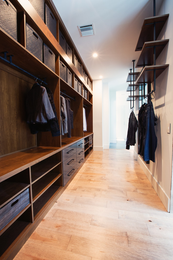 Design ideas for a mid-sized contemporary gender-neutral walk-in wardrobe in Orlando with open cabinets, dark wood cabinets and light hardwood floors.