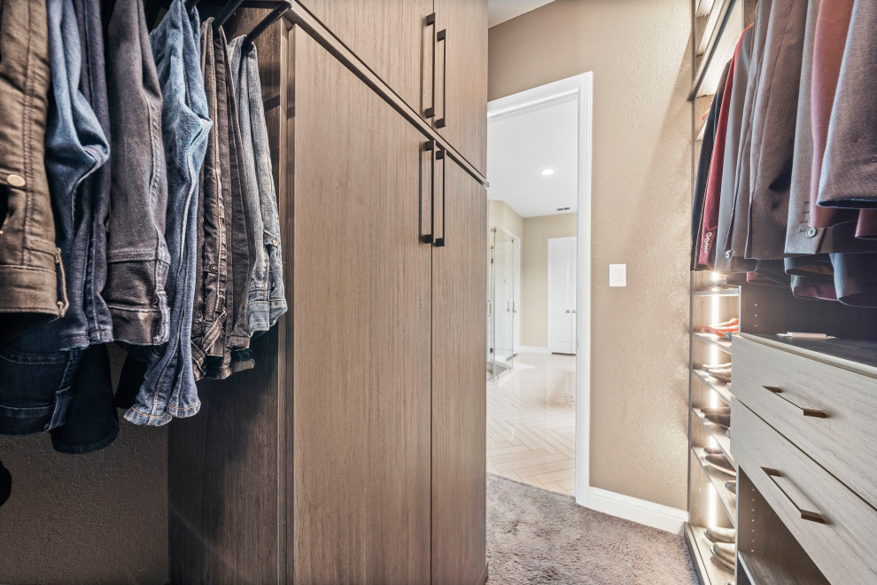 Imagen de armario vestidor unisex y abovedado minimalista grande con puertas de armario de madera clara, moqueta y suelo gris