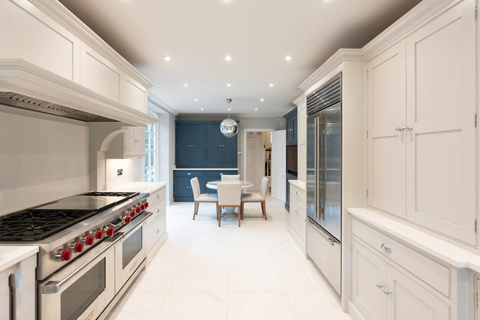 Design ideas for a large traditional galley eat-in kitchen in Essex with a farmhouse sink, beaded inset cabinets, light wood cabinets, quartzite benchtops, white splashback, stone slab splashback, stainless steel appliances, marble floors, no island, white floor and white benchtop.