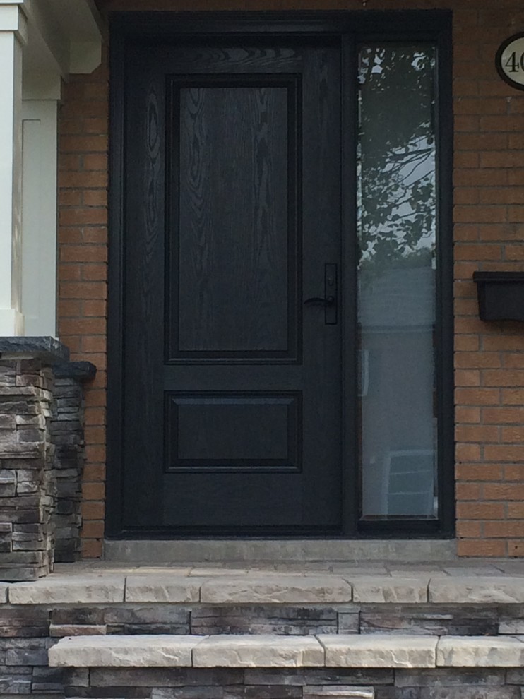 This is an example of a mid-sized arts and crafts front door in Toronto with a single front door and a dark wood front door.