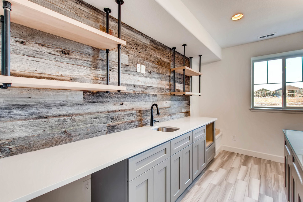 Inspiration for a mid-sized transitional galley wet bar in Denver with an undermount sink, shaker cabinets, grey cabinets, quartz benchtops, brown splashback, timber splashback, medium hardwood floors, brown floor and white benchtop.