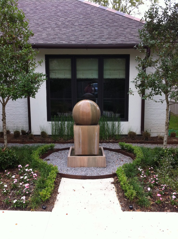 Photo of a contemporary courtyard garden in New Orleans with a water feature.