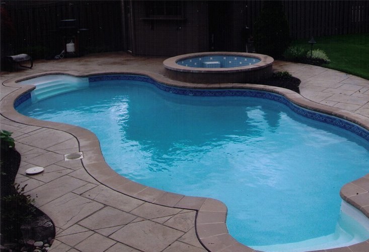 Mid-sized backyard stone and custom-shaped lap hot tub photo