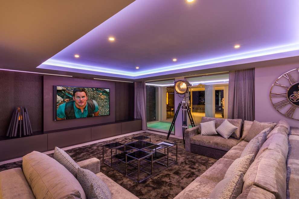 This is an example of a large contemporary enclosed home theatre in Other with grey walls, carpet, a wall-mounted tv and brown floor.