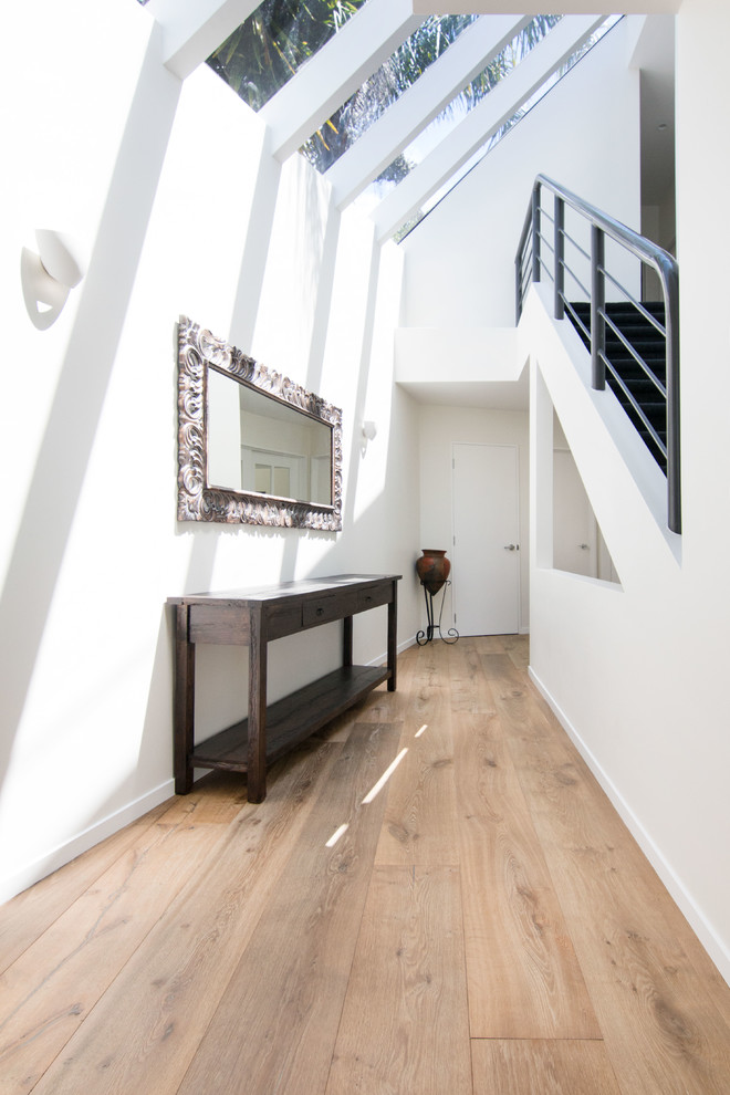 Design ideas for a mid-sized contemporary hallway in Auckland with medium hardwood floors, beige floor and white walls.