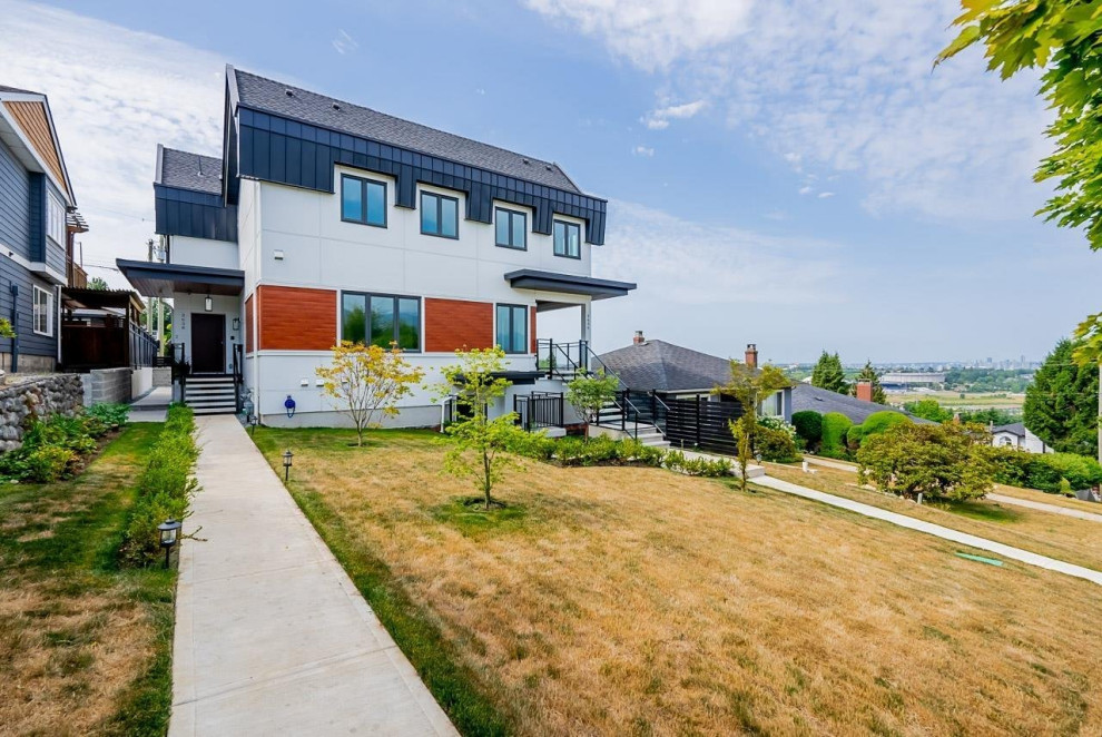 Inspiration for a mid-sized white three-story mixed siding duplex exterior remodel in Vancouver with a black roof