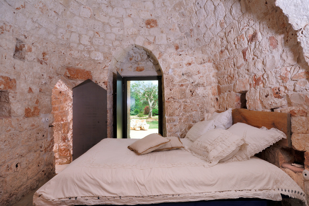 Idee per una camera matrimoniale mediterranea di medie dimensioni con pareti beige, pavimento in cemento e pavimento grigio