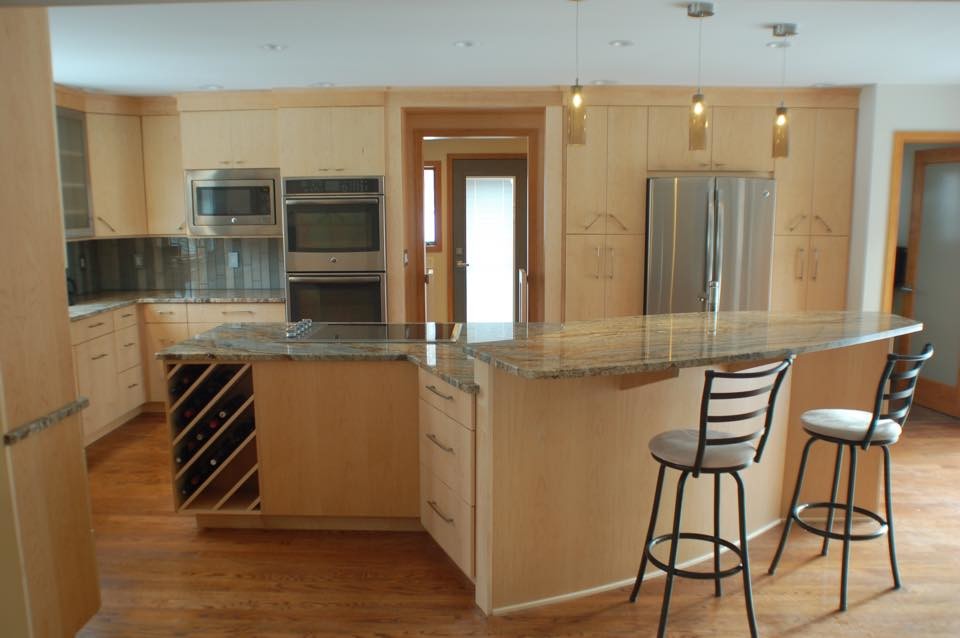 Example of a large kitchen pantry design with flat-panel cabinets and light wood cabinets