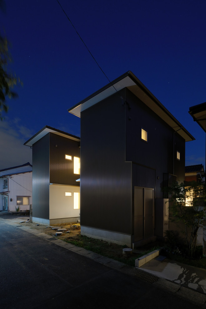 На фото: двухэтажный, коричневый дом в стиле модернизм с односкатной крышей и металлической крышей