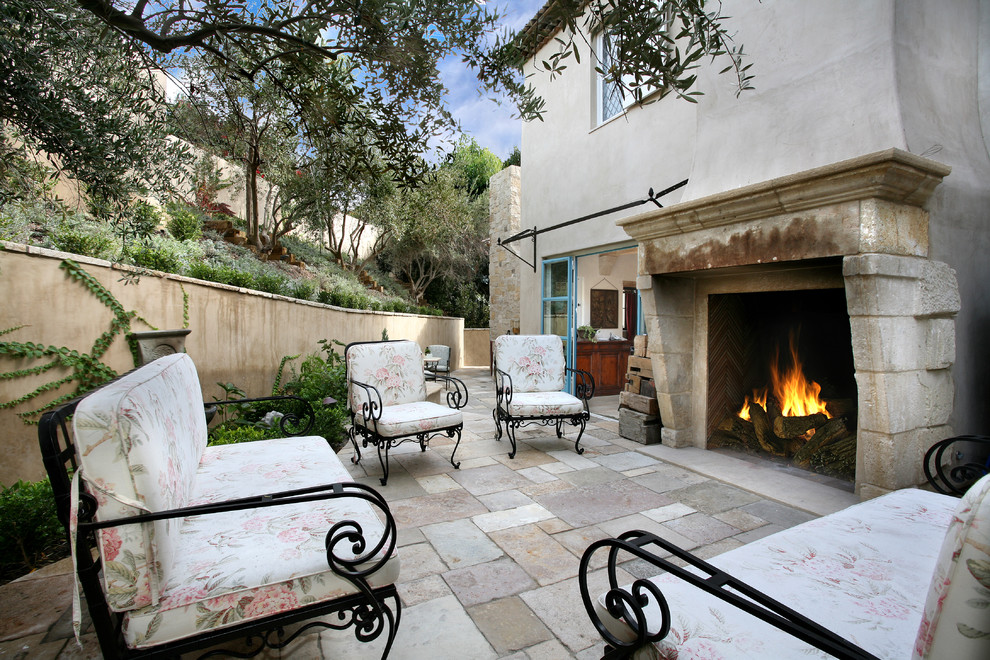 Photo of a mediterranean patio in Orange County with brick pavers and a fire feature.