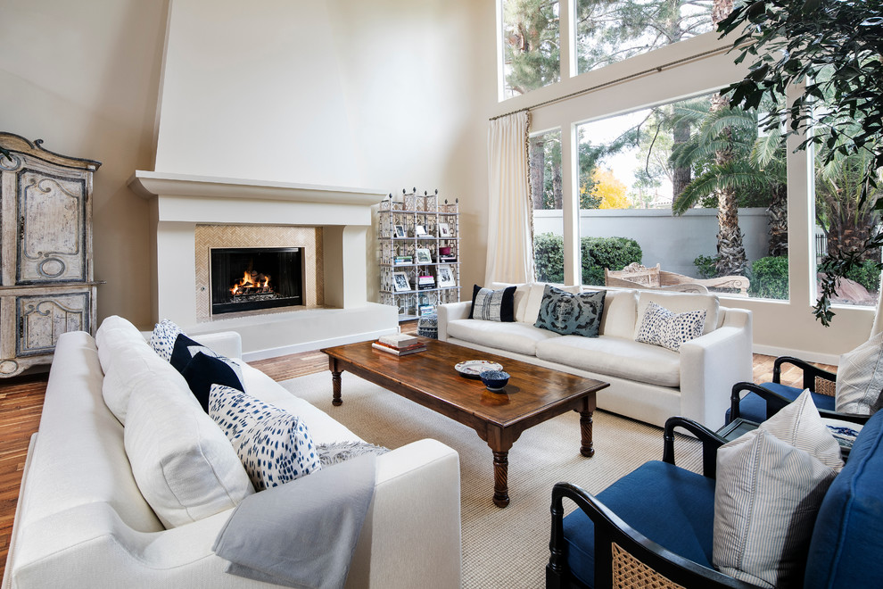 Transitional formal open concept living room in Los Angeles with beige walls, medium hardwood floors, a standard fireplace and no tv.