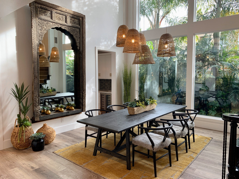 Large tropical open plan dining in Orange County with white walls, medium hardwood floors and brown floor.