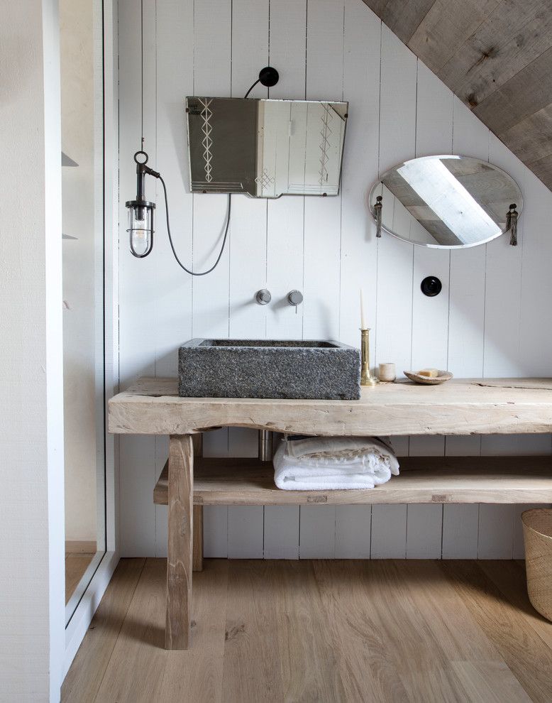 Country bathroom in Paris with open cabinets, light wood cabinets, white walls, light hardwood floors, a vessel sink and wood benchtops.