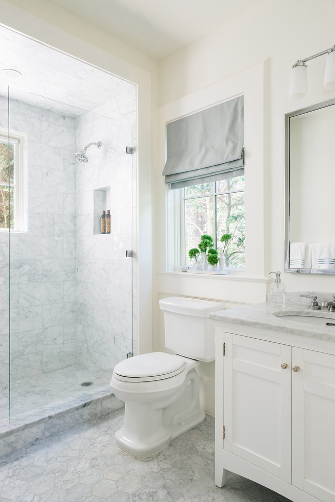This is an example of a transitional 3/4 bathroom in San Francisco with shaker cabinets, white cabinets, a corner shower, a two-piece toilet, white walls and an undermount sink.