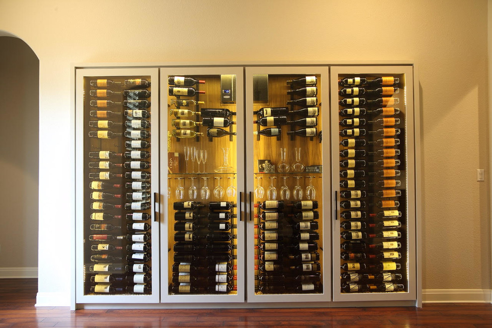 Large transitional wine cellar in Other with dark hardwood floors, display racks and brown floor.
