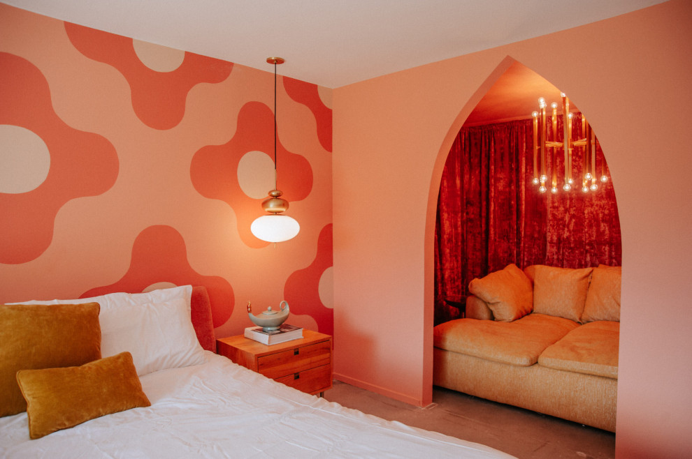 This is an example of a midcentury master bedroom in Other with pink walls and concrete floors.