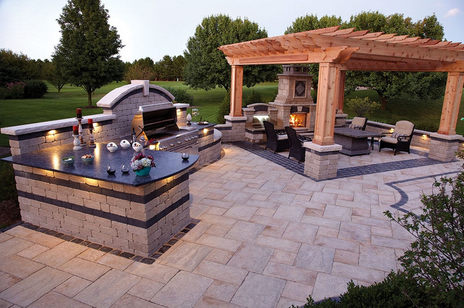 Photo of a large backyard patio in Other with an outdoor kitchen, brick pavers and a pergola.