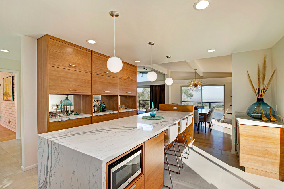 Photo of a mid-sized midcentury open plan kitchen in San Francisco with an undermount sink, flat-panel cabinets, medium wood cabinets, quartzite benchtops, white splashback, ceramic splashback, stainless steel appliances, ceramic floors, with island and beige floor.