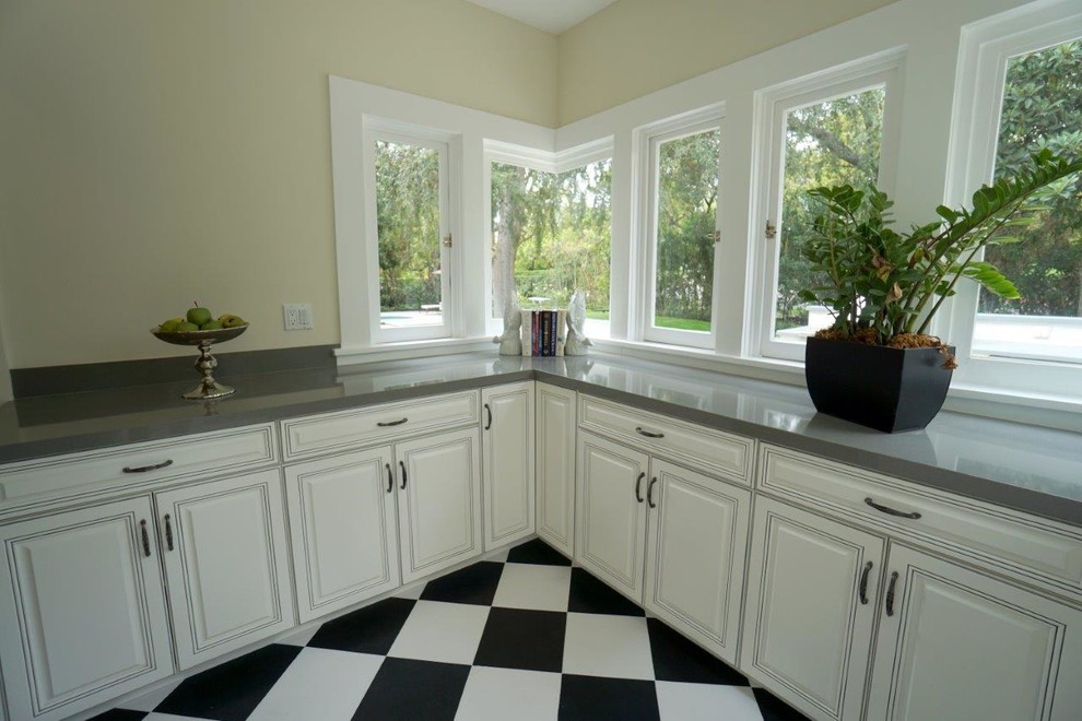 Photo of a transitional kitchen in Los Angeles with beaded inset cabinets, linoleum floors and grey benchtop.