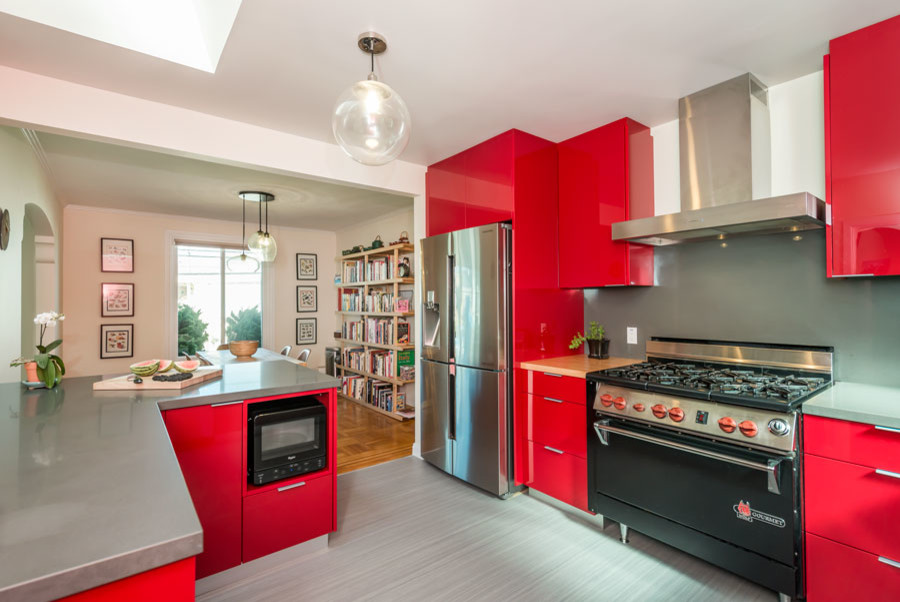 Mid-sized contemporary u-shaped eat-in kitchen in San Francisco with an undermount sink, flat-panel cabinets, red cabinets, quartz benchtops, grey splashback, stainless steel appliances, travertine splashback, linoleum floors, a peninsula and grey floor.