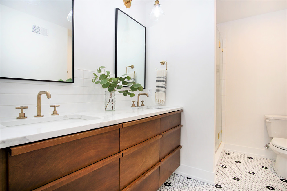 Photo of a mid-sized scandinavian master bathroom in Grand Rapids with flat-panel cabinets, dark wood cabinets, an alcove shower, a two-piece toilet, white walls, mosaic tile floors, an undermount sink, quartzite benchtops, white floor, a hinged shower door, white benchtops, white tile and subway tile.