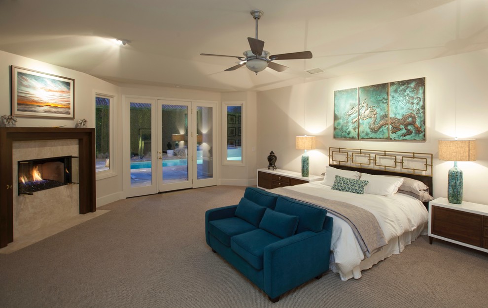 Photo of a large asian master bedroom in Los Angeles with white walls, carpet, a standard fireplace, a stone fireplace surround and beige floor.