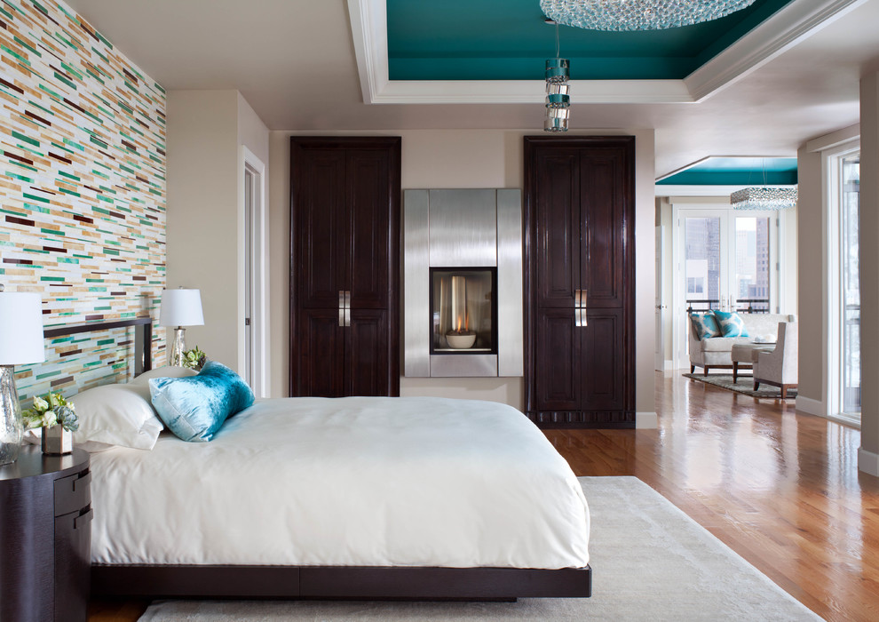 Inspiration for a contemporary medium tone wood floor bedroom remodel in Denver with a metal fireplace