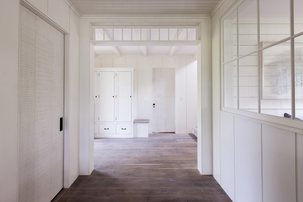 Mid-sized beach style hallway in Boston with white walls and light hardwood floors.
