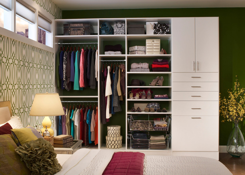 Mid-sized contemporary gender-neutral built-in wardrobe in Boston with flat-panel cabinets, white cabinets and dark hardwood floors.
