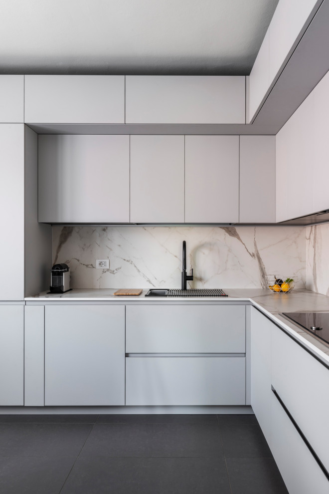Idee per una piccola cucina a L contemporanea chiusa con lavello sottopiano, ante lisce, pavimento in gres porcellanato e pavimento grigio