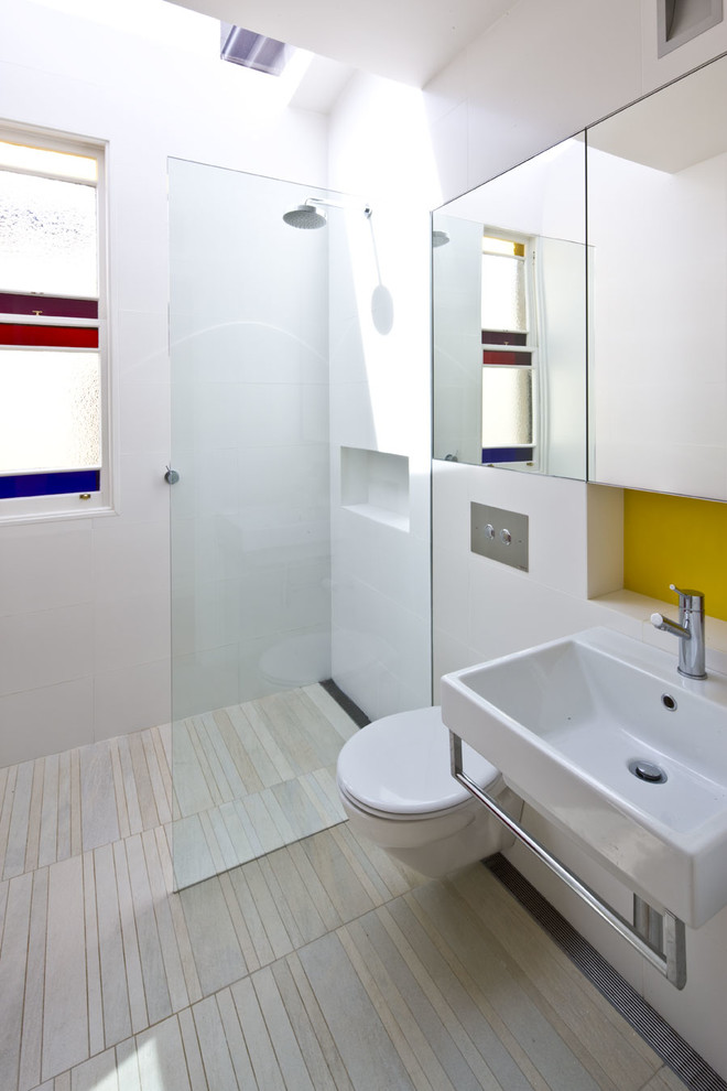 This is an example of a contemporary bathroom in Sydney with a wall-mount sink, a wall-mount toilet, white tile, a curbless shower and a niche.