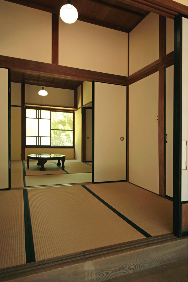 This is an example of a medium sized traditional entrance in Other with white walls, tatami flooring, a sliding front door, a medium wood front door, beige floors and a wood ceiling.