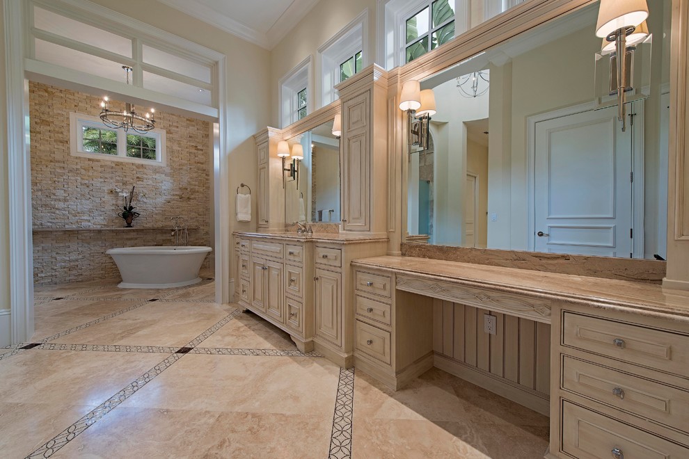 Design ideas for an expansive mediterranean master wet room bathroom in Miami with beaded inset cabinets, beige cabinets, a freestanding tub, a one-piece toilet, multi-coloured tile, stone tile, beige walls, marble floors, an undermount sink and marble benchtops.